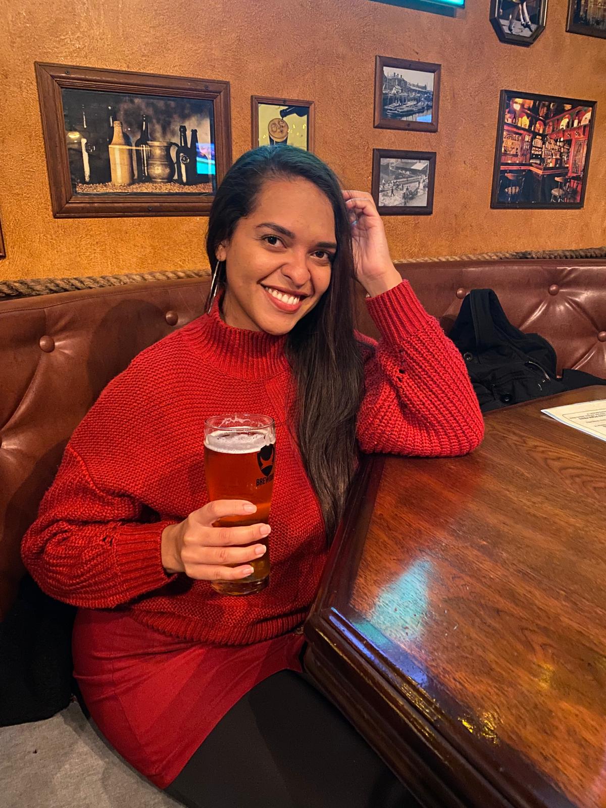 Débora Boström tomando uma cerveja em um bar